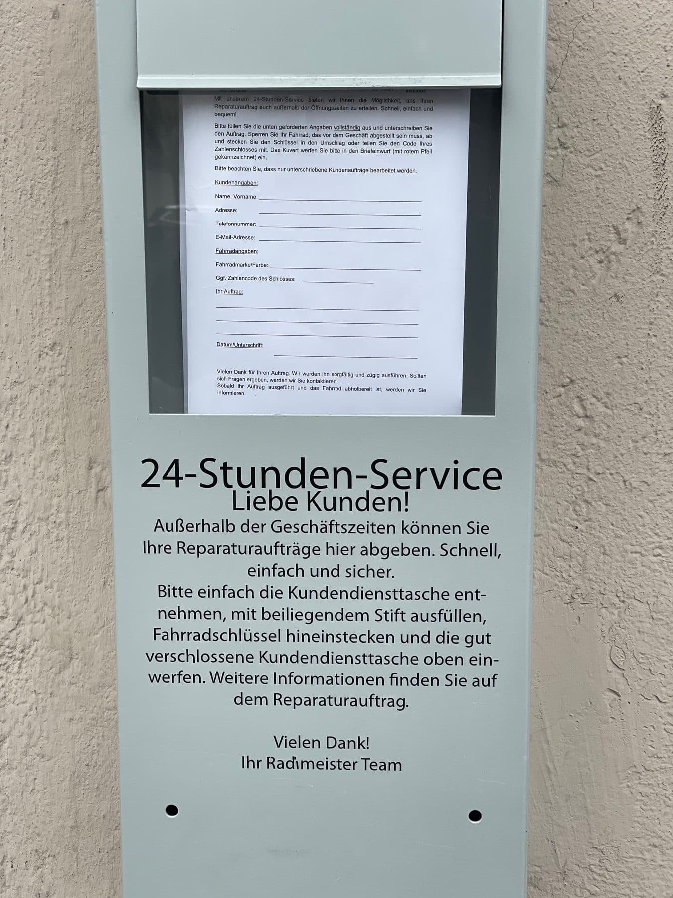Die 24-Stunden-Service-Box an der Hauswand mit Reparaturauftrag zum Ausfüllen